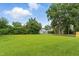 Expansive green lawn leading to a neighborhood street with mature trees and a glimpse of a home in the background at 1015 S 1St St, Smithfield, NC 27577