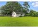 Detached garage with lawn, and mature trees, complemented by lush greenery and a serene backyard setting at 1015 S 1St St, Smithfield, NC 27577