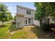 Backyard features a patio, lawn area, and a white privacy fence surrounded by lush trees at 102 Harvest Oaks Lane # 38, Durham, NC 27703