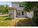 A spacious backyard featuring a concrete patio, outdoor lights, grass lawn, and partial fencing at 102 Harvest Oaks Lane # 38, Durham, NC 27703