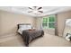 Bedroom featuring a tray ceiling, a ceiling fan, a large window, and neutral decor at 102 Harvest Oaks Lane # 38, Durham, NC 27703
