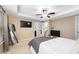 Spacious bedroom with a tray ceiling, a ceiling fan, a mirror, and a view of the ensuite bathroom at 102 Harvest Oaks Lane # 38, Durham, NC 27703