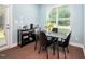Cozy dining area featuring a modern table, black chairs, and natural light from the window at 102 Harvest Oaks Lane # 38, Durham, NC 27703