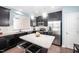 Modern kitchen featuring dark cabinets, stainless steel appliances, and a large granite island with bar stool seating at 102 Harvest Oaks Lane # 38, Durham, NC 27703
