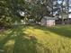 Spacious green yard features a storage shed and mature trees, creating a peaceful outdoor setting at 10248 Nc-43, Rocky Mount, NC 27801
