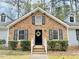 Charming one-story brick home with a welcoming black front door and manicured landscaping at 103 Cimmaron Ct, Cary, NC 27511