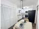 Eat-in kitchen features sleek, white cabinetry, stainless steel appliances, modern lighting, and adjacent pantry at 103 Cimmaron Ct, Cary, NC 27511