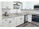 Modern kitchen featuring white cabinets, granite countertops, and stainless steel appliances at 103 Cimmaron Ct, Cary, NC 27511