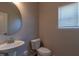 Powder room with modern fixtures, including a round mirror and pedestal sink at 108 Freedom Heights Ln # 147, Smithfield, NC 27577