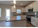Bright kitchen featuring gray countertop island with stainless steel appliances, modern fixtures and a door to the backyard at 108 Freedom Heights Ln # 147, Smithfield, NC 27577
