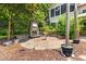 Backyard patio with an outdoor fireplace, stone pavers, and established landscaping for an inviting retreat at 11124 Penderwood Ct, Raleigh, NC 27617