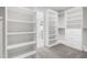 Open walk-in closet featuring ample shelving, drawers, and access to the bathroom at 11124 Penderwood Ct, Raleigh, NC 27617