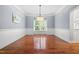 Dining room featuring chair rail, hardwood flooring, modern chandelier and large window at 11124 Penderwood Ct, Raleigh, NC 27617