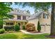 Charming two-story yellow home with a well-manicured lawn, mature trees, and inviting front porch at 11124 Penderwood Ct, Raleigh, NC 27617