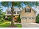 Lovely two-story home with a three car garage, dormer windows, beautiful landscaping, and lush green lawn at 11124 Penderwood Ct, Raleigh, NC 27617