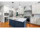 Bright kitchen featuring a navy blue island, white cabinets, stainless steel appliances, and hardwood floors at 11124 Penderwood Ct, Raleigh, NC 27617