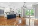 Bright kitchen featuring a navy blue island, white cabinets, stainless steel appliances, and hardwood floors at 11124 Penderwood Ct, Raleigh, NC 27617
