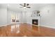 Bright living room with a fireplace, ceiling fan, hardwood flooring and patio doors offers a cozy space at 11124 Penderwood Ct, Raleigh, NC 27617