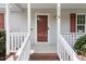 Close-up of the front porch with a red front door, white railing, and brick steps at 1113 Curtiss Dr, Garner, NC 27529