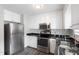 Bright kitchen featuring white cabinets, black countertops, and stainless steel appliances at 1113 Curtiss Dr, Garner, NC 27529