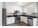 Well-lit kitchen featuring white cabinets, stainless steel appliances, and black granite countertops at 1113 Curtiss Dr, Garner, NC 27529