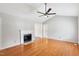 Cozy living room featuring a fireplace, ceiling fan, and hardwood floors, open to a hallway at 1113 Curtiss Dr, Garner, NC 27529