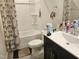 Bathroom featuring a dark vanity, toilet, and tub-shower combo with shower curtain at 112 Wilbur Lake Dr, Fuquay Varina, NC 27526