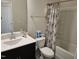 Bathroom features a black vanity, toilet, and tub-shower combo with shower curtain at 112 Wilbur Lake Dr, Fuquay Varina, NC 27526