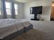 Carpeted bedroom with ample space featuring large windows, a TV, and an attached bathroom at 112 Wilbur Lake Dr, Fuquay Varina, NC 27526