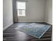 Bedroom featuring hardwood floors, a modern rug, and a window with neutral-tone curtains at 112 Wilbur Lake Dr, Fuquay Varina, NC 27526