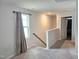 Bright upstairs hallway with carpet, window, and view into an adjacent bedroom at 112 Wilbur Lake Dr, Fuquay Varina, NC 27526