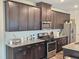 Beautiful kitchen with dark cabinets, granite countertops, and stainless steel appliances at 112 Wilbur Lake Dr, Fuquay Varina, NC 27526