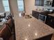 Kitchen island with granite counters, stainless steel sink, and brown cabinets at 112 Wilbur Lake Dr, Fuquay Varina, NC 27526