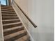 Carpeted staircase with wood handrail leads to upper level at 112 Wilbur Lake Dr, Fuquay Varina, NC 27526