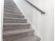 Carpeted staircase with a wooden handrail against bright white walls at 112 Wilbur Lake Dr, Fuquay Varina, NC 27526