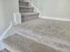 Close-up of carpeted stairs with white trim and neutral tones at 112 Wilbur Lake Dr, Fuquay Varina, NC 27526