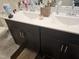 Bathroom with a dark vanity featuring double sinks, countertop, and cabinet storage at 112 Wilbur Lake Dr, Fuquay Varina, NC 27526