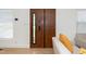 A modern wood front door with a window, complemented by light walls and wood flooring at 1128 E Geer St, Durham, NC 27704