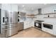 Renovated kitchen with white cabinetry, stainless steel appliances, and modern open shelving at 1128 E Geer St, Durham, NC 27704
