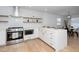 Beautiful open kitchen featuring white cabinetry, stainless steel appliances and an island with counter seating at 1128 E Geer St, Durham, NC 27704