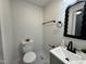 A bathroom with a modern toilet, a gray vanity, and a black mirror at 1336 Hill Street St, Rocky Mount, NC 27801