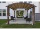 Backyard patio under pergola with patio furniture next to sliding glass door entrance at 14 Shady Oaks Rd, Angier, NC 27501