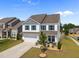 Beautiful two-story home with a manicured lawn, attached garage, and welcoming porch with comfortable seating at 14 Shady Oaks Rd, Angier, NC 27501