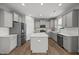Well-lit kitchen featuring gray cabinets, a kitchen island, and stainless steel appliances, offering ample workspace at 14 Shady Oaks Rd, Angier, NC 27501