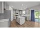 Modern kitchen with gray cabinets, a center island, stainless steel appliances, and access to outdoor patio at 14 Shady Oaks Rd, Angier, NC 27501