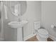 Charming powder room with pedestal sink, round mirror, toilet, and wood-look floors at 14 Shady Oaks Rd, Angier, NC 27501