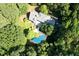 Aerial view of estate featuring a pool surrounded by mature trees, a back patio and lush landscaping at 14236 Wyndfield Cir, Raleigh, NC 27615