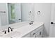 Bright bathroom featuring double vanity, white cabinets, and modern black hardware at 14236 Wyndfield Cir, Raleigh, NC 27615
