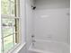 Bright bathroom with white tiled shower and tub, next to a window at 14236 Wyndfield Cir, Raleigh, NC 27615