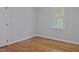Bedroom featuring hardwood floors, gray walls, white trim, and natural light at 14236 Wyndfield Cir, Raleigh, NC 27615